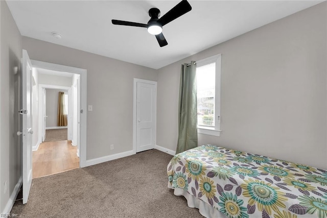 carpeted bedroom featuring ceiling fan and baseboards