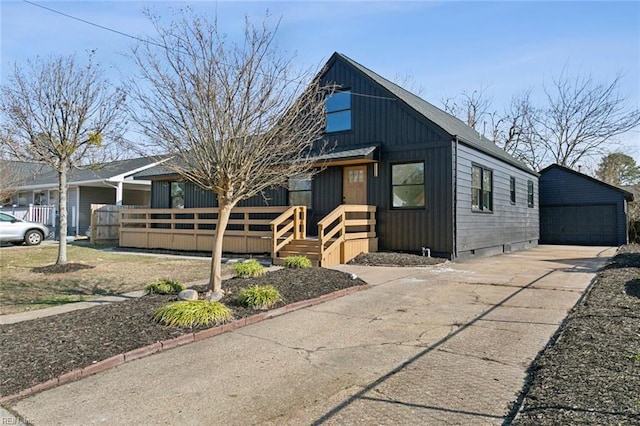 view of front of home with a garage, board and batten siding, and an outdoor structure