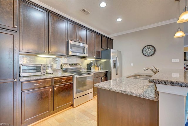 kitchen featuring a toaster, visible vents, appliances with stainless steel finishes, a sink, and backsplash