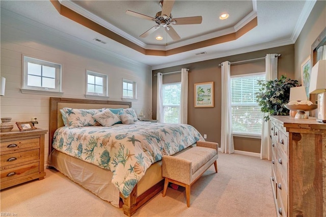 bedroom featuring a tray ceiling, multiple windows, and visible vents