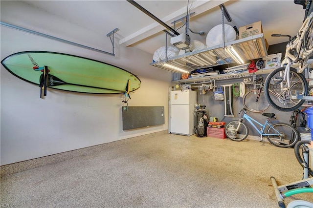 garage with freestanding refrigerator and a garage door opener