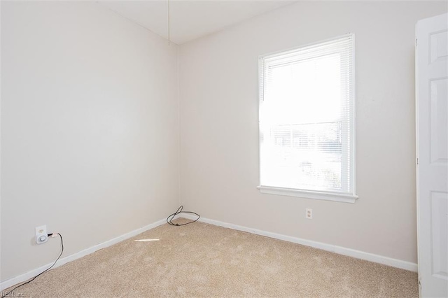 empty room featuring carpet and baseboards