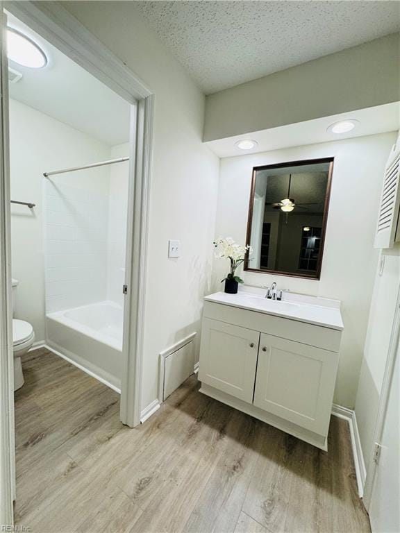 bathroom featuring vanity, wood finished floors, toilet, and baseboards