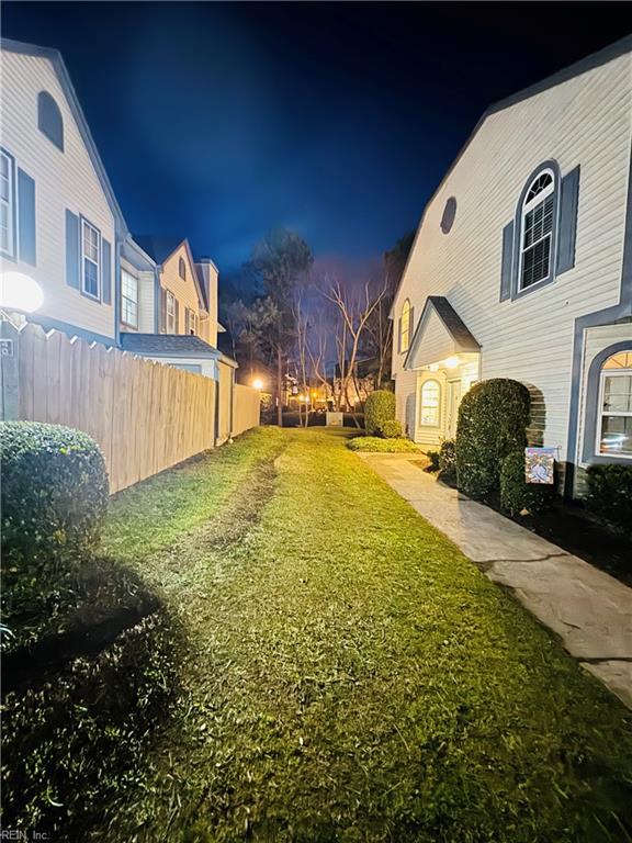 yard at twilight featuring fence