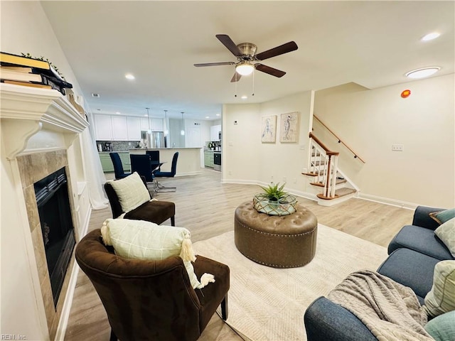 living room with baseboards, stairway, light wood-type flooring, and recessed lighting