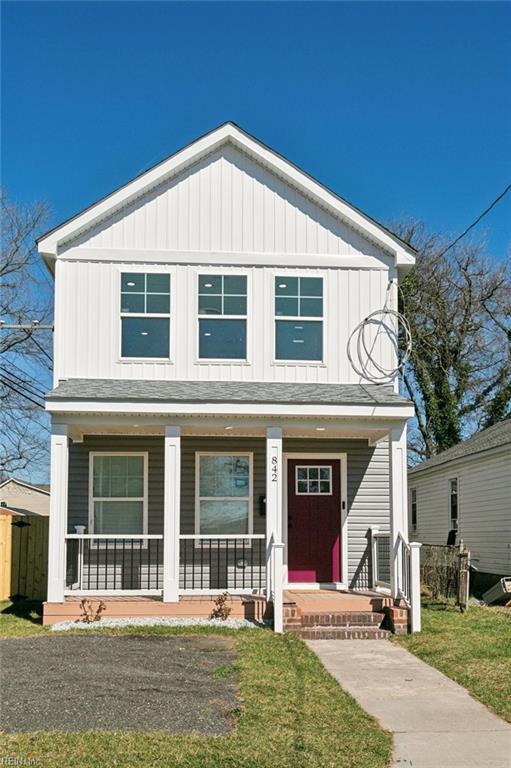 view of front of home featuring covered porch, board and batten siding, and a front yard