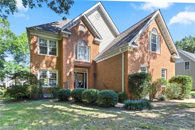 view of front facade with a front lawn and brick siding