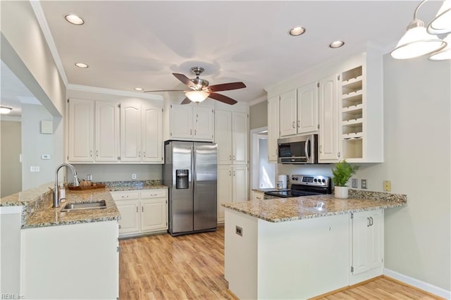 kitchen featuring a peninsula, light stone countertops, stainless steel appliances, crown molding, and a sink