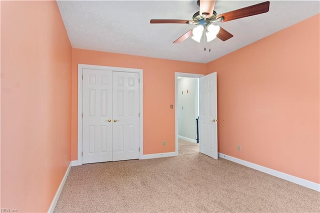 unfurnished bedroom with ceiling fan, a closet, carpet flooring, and baseboards