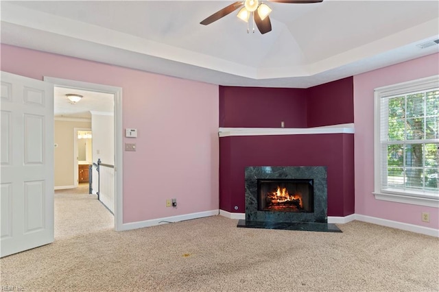 unfurnished living room with carpet floors, a fireplace, visible vents, a ceiling fan, and baseboards