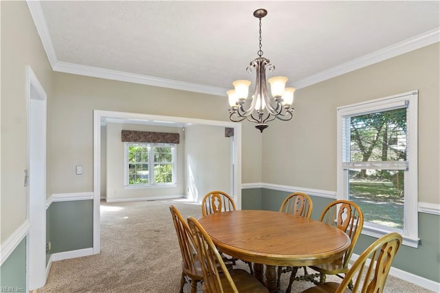 dining room with a notable chandelier, crown molding, baseboards, and carpet flooring