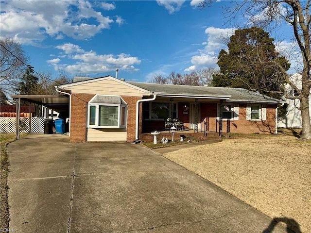 ranch-style house featuring covered porch, concrete driveway, brick siding, and an attached carport