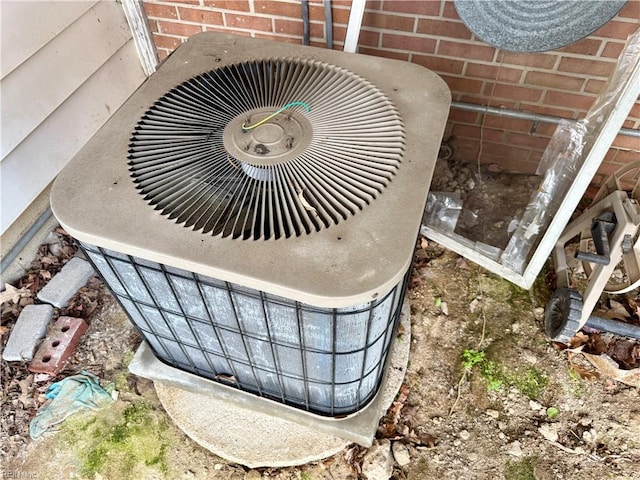 exterior details featuring central AC and brick siding