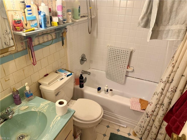 bathroom featuring shower / bath combo, toilet, tile patterned floors, vanity, and tile walls