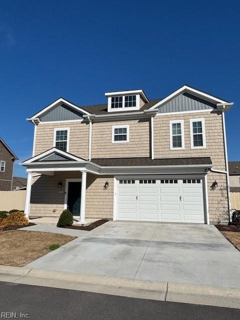 view of front of property featuring a garage, fence, and concrete driveway