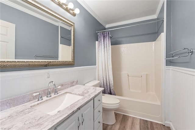 bathroom with wainscoting, toilet, wood finished floors, crown molding, and vanity