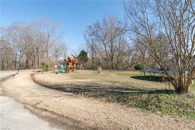 view of playground with a trampoline and a lawn