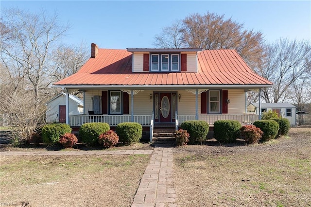 view of front of house with covered porch, metal roof, and a chimney