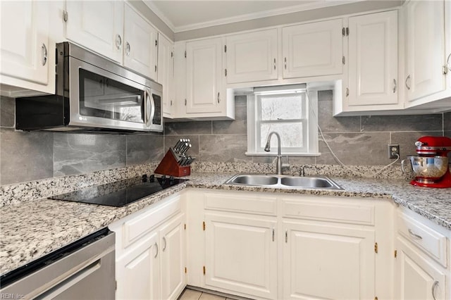 kitchen featuring white cabinetry, appliances with stainless steel finishes, tasteful backsplash, and a sink