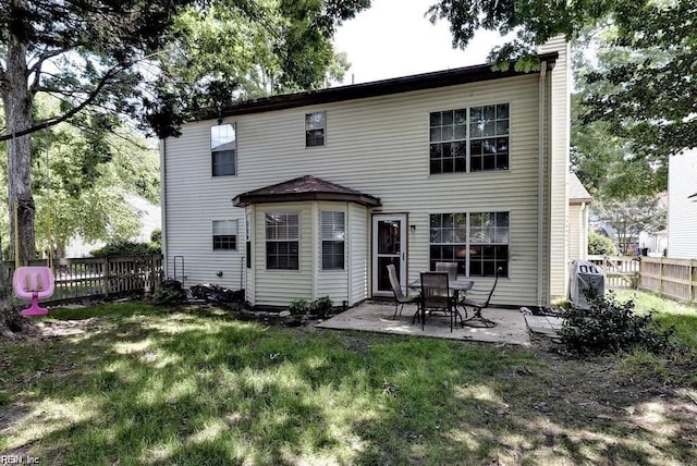 rear view of house with a yard, fence, and a patio