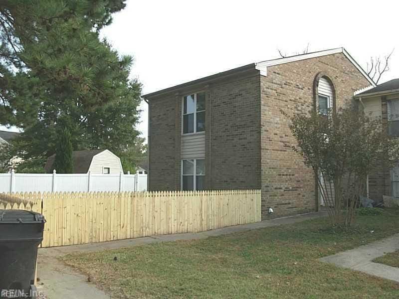 view of side of property with fence and brick siding