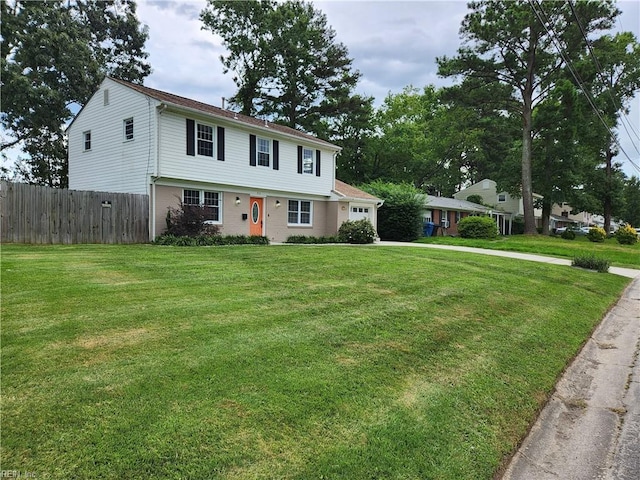 view of front of house featuring a garage, driveway, fence, and a front yard