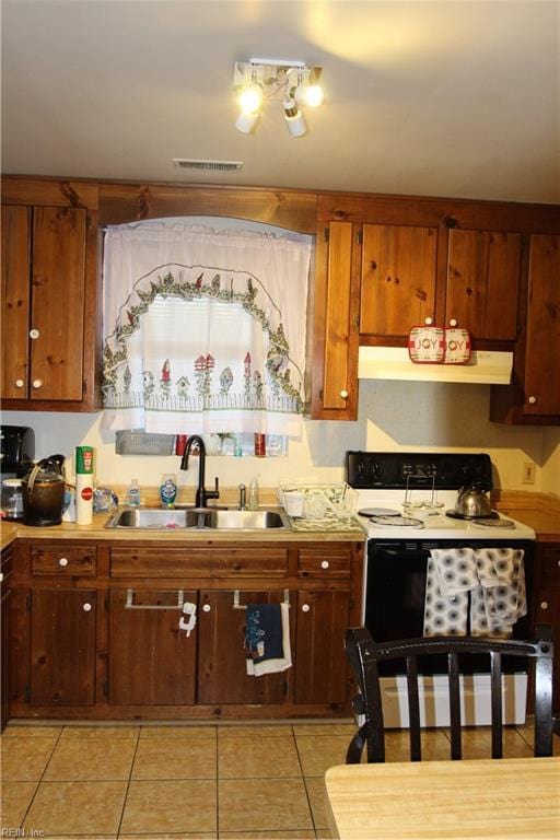 kitchen featuring light tile patterned floors, light countertops, electric range oven, a sink, and exhaust hood