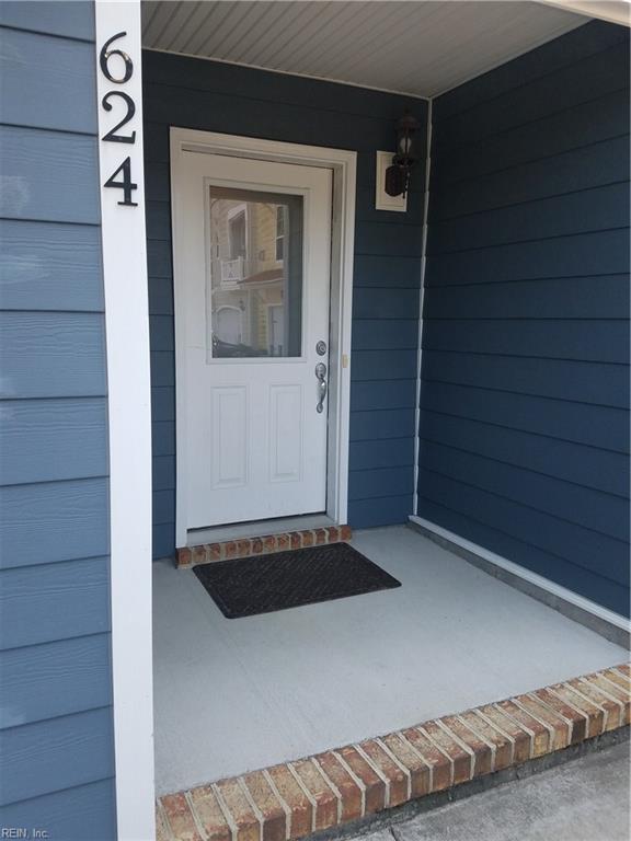 view of exterior entry featuring a garage and a porch