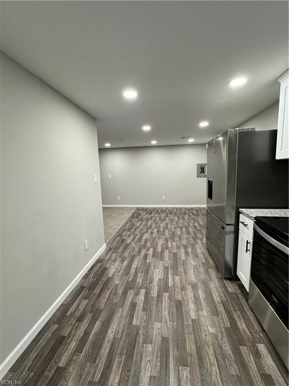 kitchen featuring stainless steel range with electric stovetop, white cabinetry, and dark wood-style floors