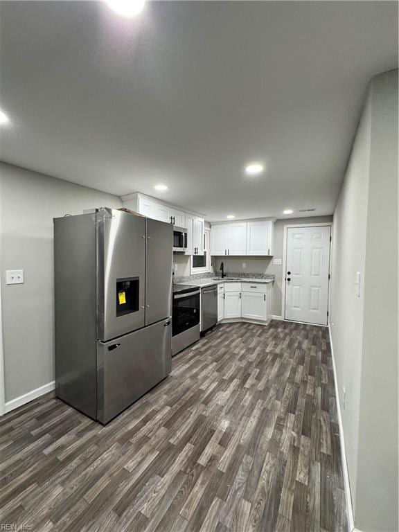 kitchen featuring light countertops, appliances with stainless steel finishes, dark wood-type flooring, and white cabinetry