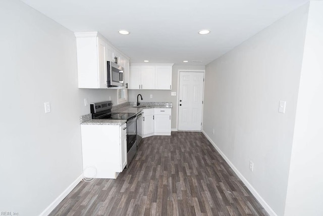 kitchen with baseboards, white cabinetry, stainless steel appliances, and a sink