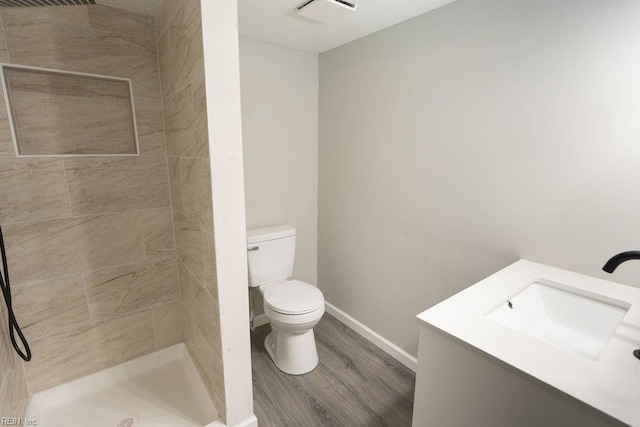 full bathroom with visible vents, toilet, a stall shower, wood finished floors, and baseboards