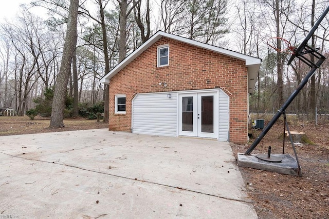 rear view of property with brick siding, cooling unit, and french doors