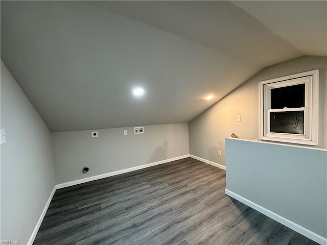 additional living space featuring dark wood-style floors, vaulted ceiling, and baseboards