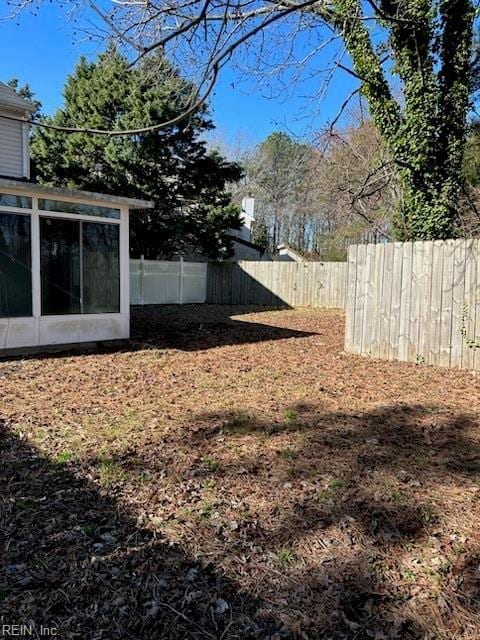 view of yard featuring a sunroom and fence