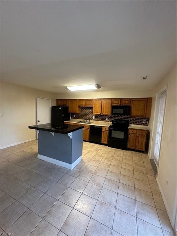 kitchen with light tile patterned floors, black appliances, a sink, and backsplash