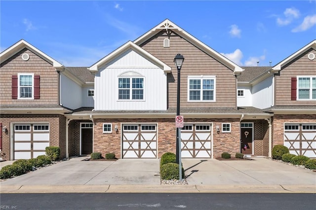 townhome / multi-family property featuring board and batten siding, stone siding, driveway, and an attached garage