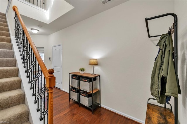 stairs featuring a skylight, wood-type flooring, and baseboards