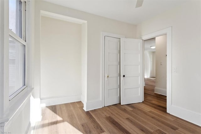 unfurnished bedroom featuring a closet, wood finished floors, and baseboards