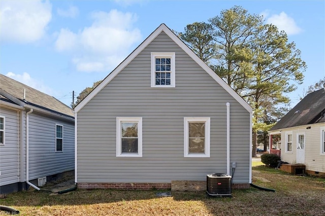 view of property exterior with central AC and a yard