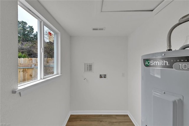 laundry area with laundry area, wood finished floors, visible vents, and baseboards