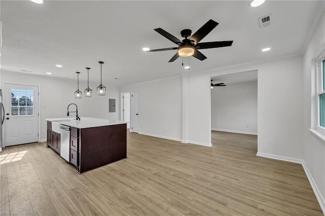 kitchen with a center island with sink, light countertops, visible vents, stainless steel dishwasher, and light wood-style floors