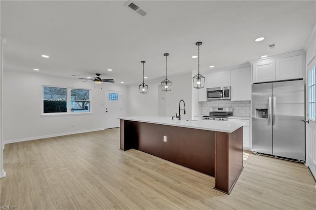 kitchen with appliances with stainless steel finishes, light countertops, visible vents, and decorative backsplash