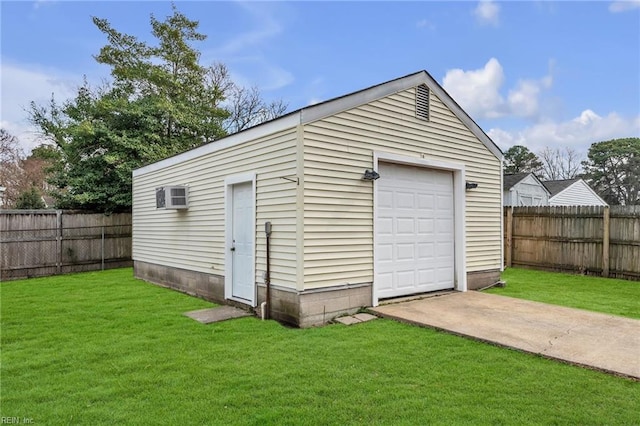 detached garage featuring concrete driveway, a wall unit AC, and fence