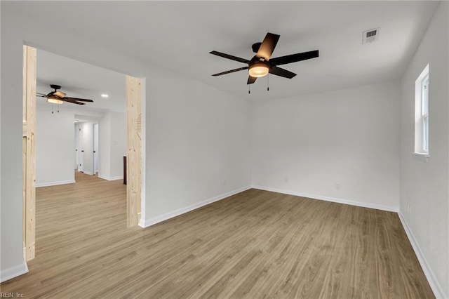 empty room featuring baseboards, visible vents, and wood finished floors