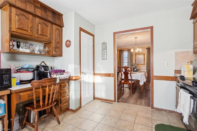 kitchen with light tile patterned floors, black microwave, visible vents, light countertops, and a chandelier