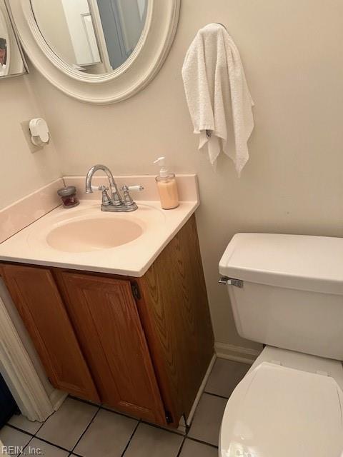 half bathroom featuring vanity, toilet, and tile patterned floors