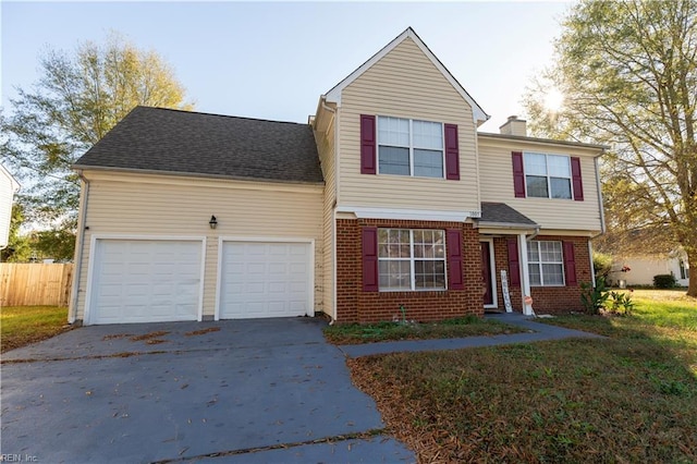 traditional-style home with brick siding, driveway, an attached garage, and fence