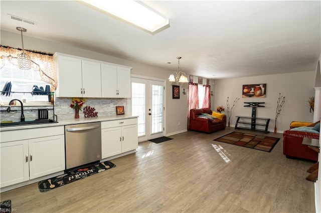 kitchen featuring open floor plan, stainless steel dishwasher, a sink, and visible vents