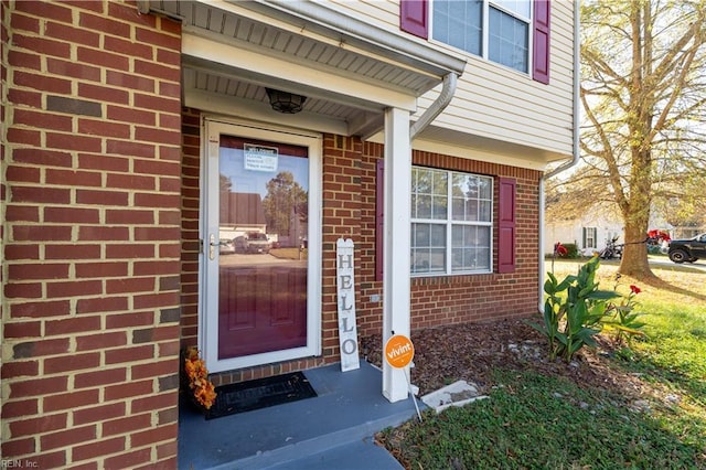 view of exterior entry featuring brick siding